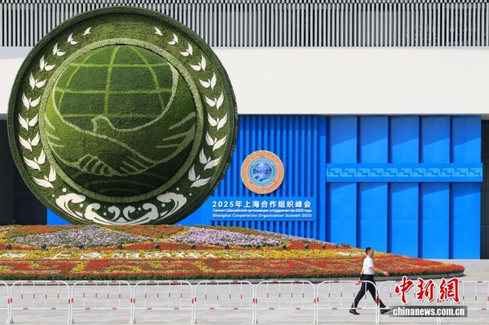 8月31日，天津，一名工作人员从2025年上海合作组织峰会主会场外的景观花坛旁经过。当日，2025年上海合作组织峰会在天津举行。<a target='_blank' href='/'><p align=